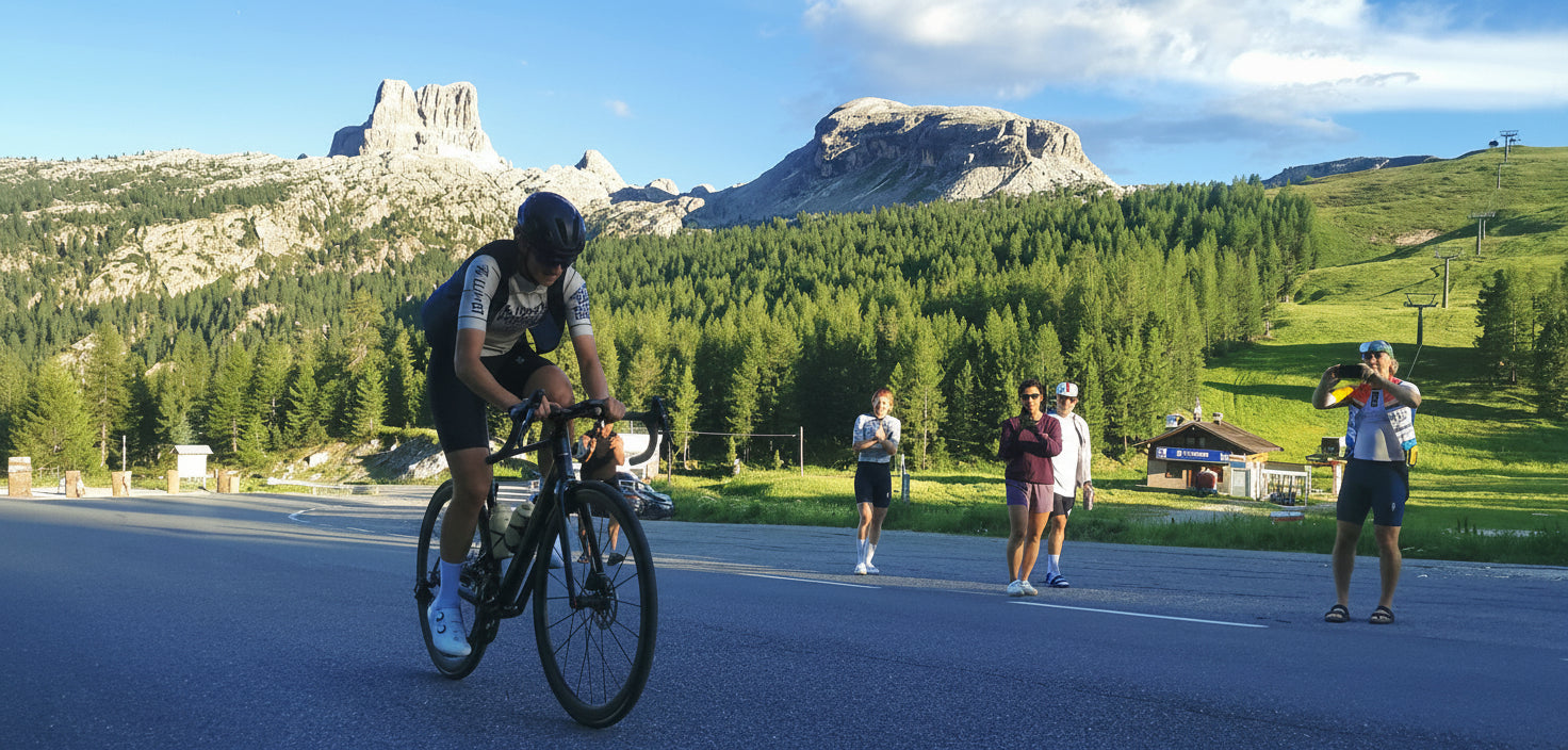 Biker on a road with people and scenic landscape